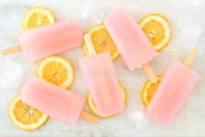 Ρόδινη λεμονάδα popsicles με τις φέτες λεμονιών στο άσπρο μάρμαρο στοκ εικόνα