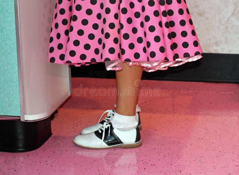 Girl is wearing a bright pink with black polka dotted poodle skirt with the slip showing! Black and white saddle shoes complete this 1950's era teen outfit. Girl is wearing a bright pink with black polka dotted poodle skirt with the slip showing! Black and white saddle shoes complete this 1950's era teen outfit.