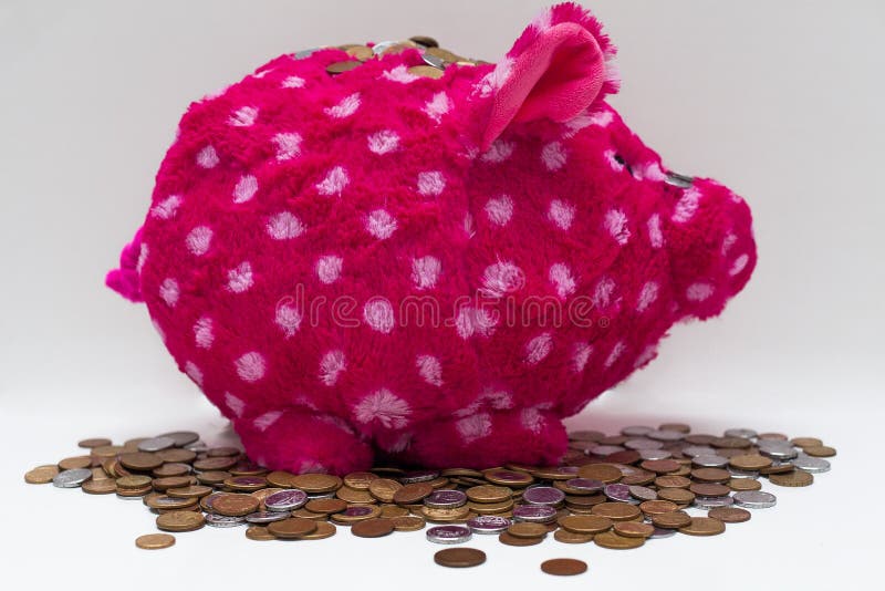 Ρόδινα τράπεζα και νομίσματα Piggy βελούδου στοκ εικόνα με δικαίωμα ελεύθερης χρήσης Ρόδινα τράπεζα και νομίσματα Piggy βελούδου στοκ εικόνα με δικαίωμα ελεύθερης χρήσης