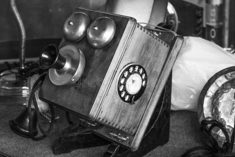 Sao Paulo / Sao Paulo / Brazil - 08 19 2018: Old heavy wood and metal vintage telephone in a desk at flea market; It`s an antiquity item for collection. [Black and White version]. Sao Paulo / Sao Paulo / Brazil - 08 19 2018: Old heavy wood and metal vintage telephone in a desk at flea market; It`s an antiquity item for collection. [Black and White version]