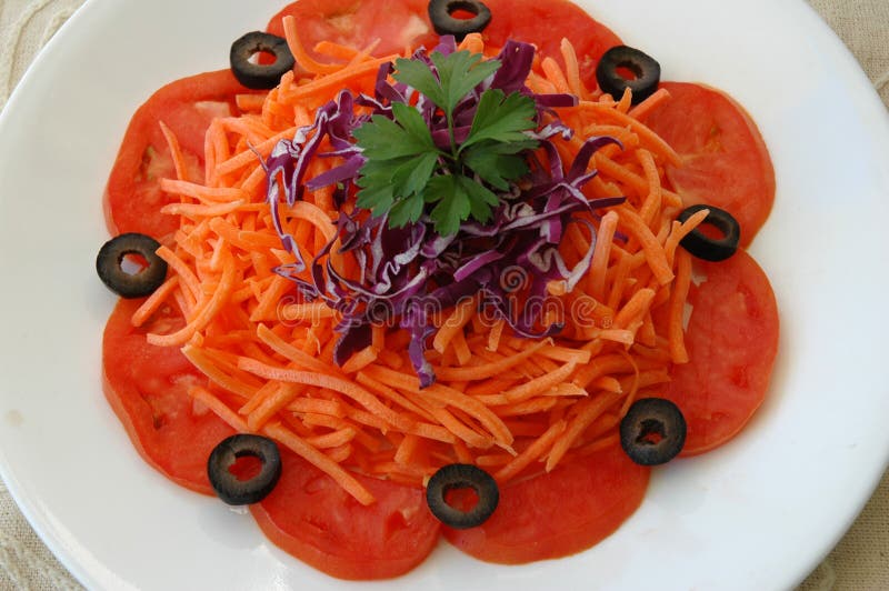 Carrot salad with red cabbage, tomatoes, and black olives. Carrot salad with red cabbage, tomatoes, and black olives