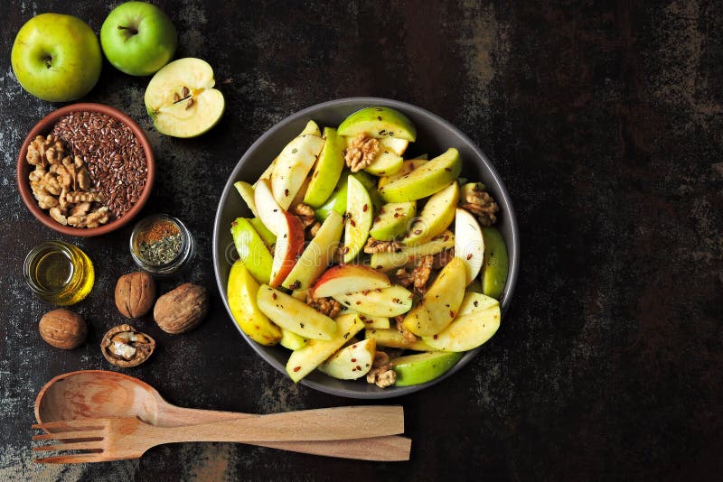 Vegan apple salad in a bowl. Healthy salad with apples, walnuts, spices and flax seeds. Useful autumn apple and nut salad. Fitness salad with seeds, nuts, apples. Healthy nutrition concept. Keto snack. Vegan apple salad in a bowl. Healthy salad with apples, walnuts, spices and flax seeds. Useful autumn apple and nut salad. Fitness salad with seeds, nuts, apples. Healthy nutrition concept. Keto snack