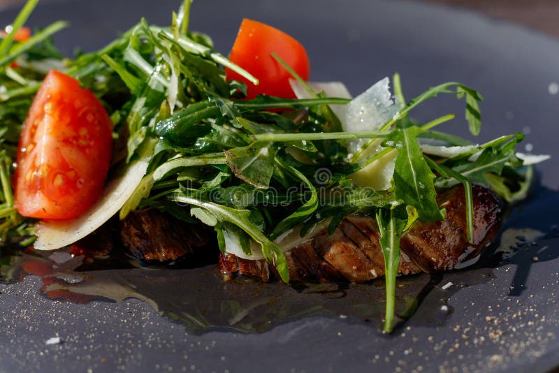 Σαλάτα μπριζόλας μοσχαρίσιων κρεάτων με το arugula, μαρούλι, μισά των μικρών ντοματών κερασιών, τυρί παρμεζάνας στοκ εικόνα με δικαίωμα ελεύθερης χρήσης Σαλάτα μπριζόλας μοσχαρίσιων κρεάτων με το arugula, μαρούλι, μισά των μικρών ντοματών κερασιών, τυρί παρμεζάνας στοκ εικόνα με δικαίωμα ελεύθερης χρήσης