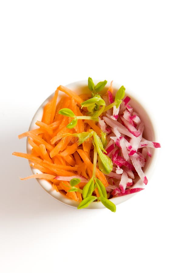 Carrot and radish salad in white bowl on white background. Carrot and radish salad in white bowl on white background