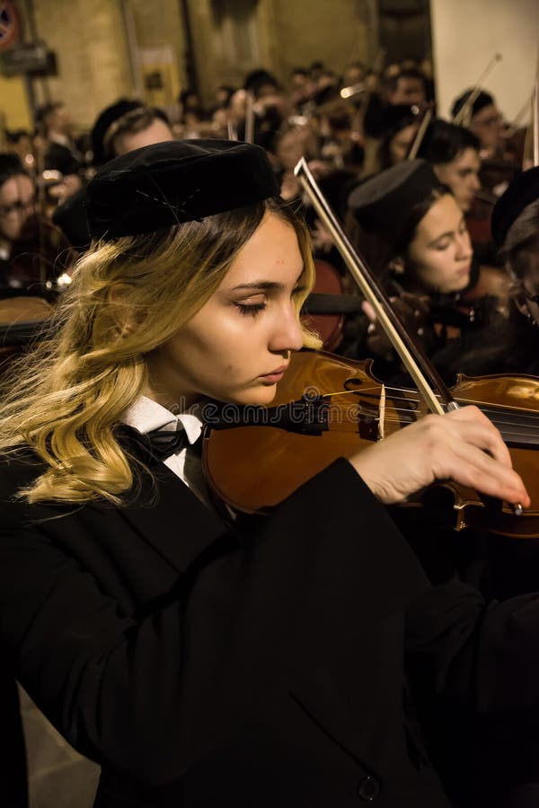 Chieti, Italy - 29 March 2024: Cellist during the famous Good Friday procession in Chieti (Italy. Chieti, Italy - 29 March 2024: Cellist during the famous Good Friday procession in Chieti (Italy