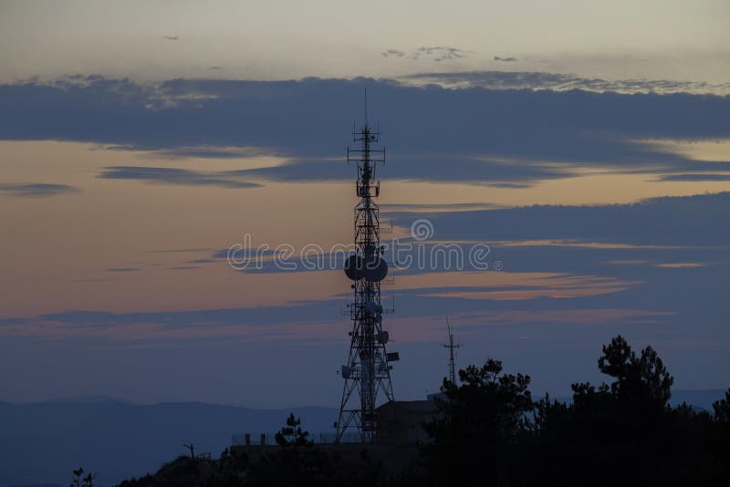Σιλουέτα πύργου τηλεπικοινωνιών στο ηλιοβασίλεμα που φωτίζει πολύχρωμα σύννεφα στοκ εικόνα με δικαίωμα ελεύθερης χρήσης