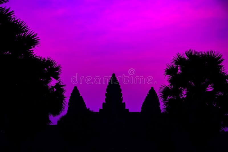 Silhouette of Cambodian ancient temple Angkor wat, Angkor Archaeological Park near Siem Reap in Cambodia. Panorama Mist sunrise tropical morning violet mauve colorful sky landscape Palm trees. Silhouette of Cambodian ancient temple Angkor wat, Angkor Archaeological Park near Siem Reap in Cambodia. Panorama Mist sunrise tropical morning violet mauve colorful sky landscape Palm trees.