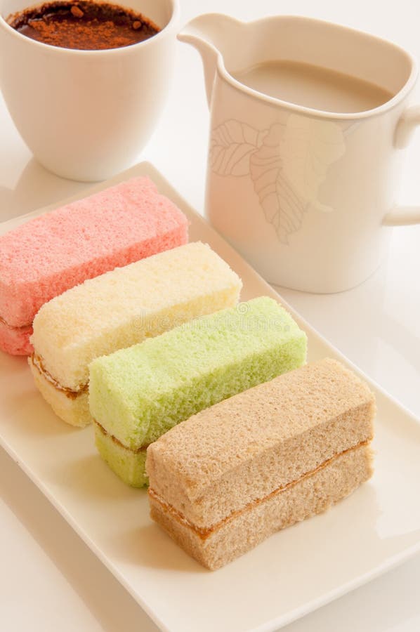 Colorful chiffon cake pieces with cups of milk and hot coco. Colorful chiffon cake pieces with cups of milk and hot coco.