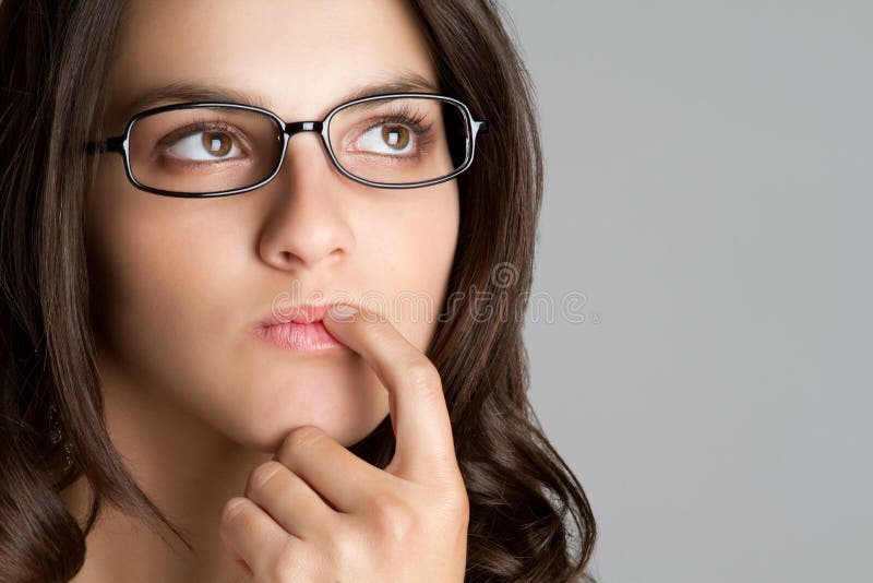 Young eyeglasses girl thinking closeup. Young eyeglasses girl thinking closeup