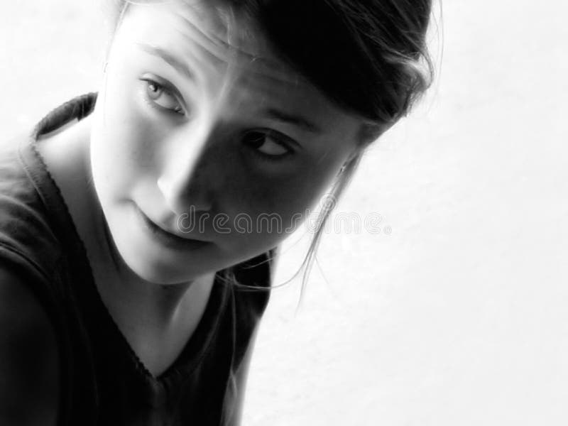Young girl looking over shoulder, lost in thought, black and white. Young girl looking over shoulder, lost in thought, black and white