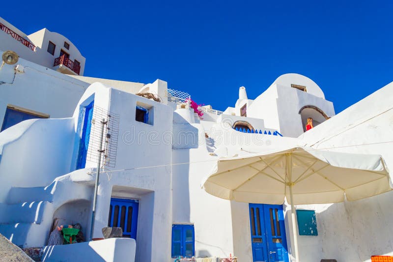 Picturesque white carved houses with blue doors in Oia.The town has whitewashed houses carved into the rugged clifftops, and overlooks a vast caldera filled with water.Santorini is one of the Cyclades islands in the Aegean Sea. The whitewashed, cubiform houses of its 2 principal towns, Fira and Oia, cling to cliffs above an underwater caldera (crater),September 4th 2013. Picturesque white carved houses with blue doors in Oia.The town has whitewashed houses carved into the rugged clifftops, and overlooks a vast caldera filled with water.Santorini is one of the Cyclades islands in the Aegean Sea. The whitewashed, cubiform houses of its 2 principal towns, Fira and Oia, cling to cliffs above an underwater caldera (crater),September 4th 2013