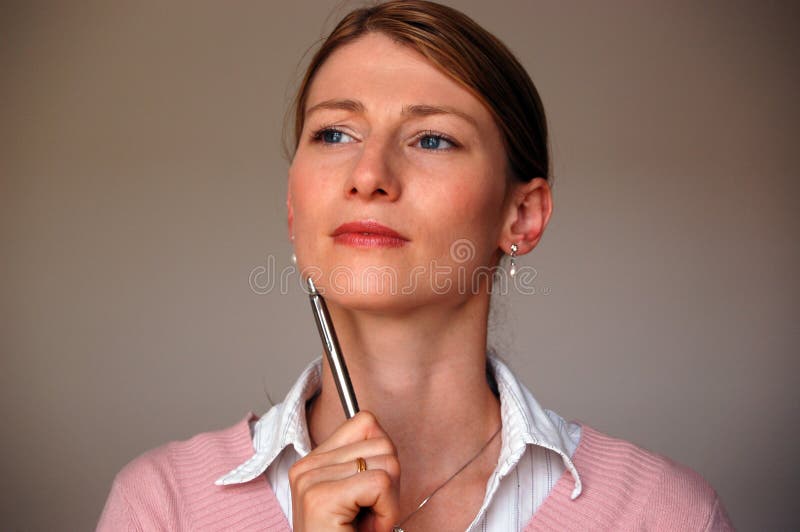 Young businesswoman holding pen and thinking. Young businesswoman holding pen and thinking