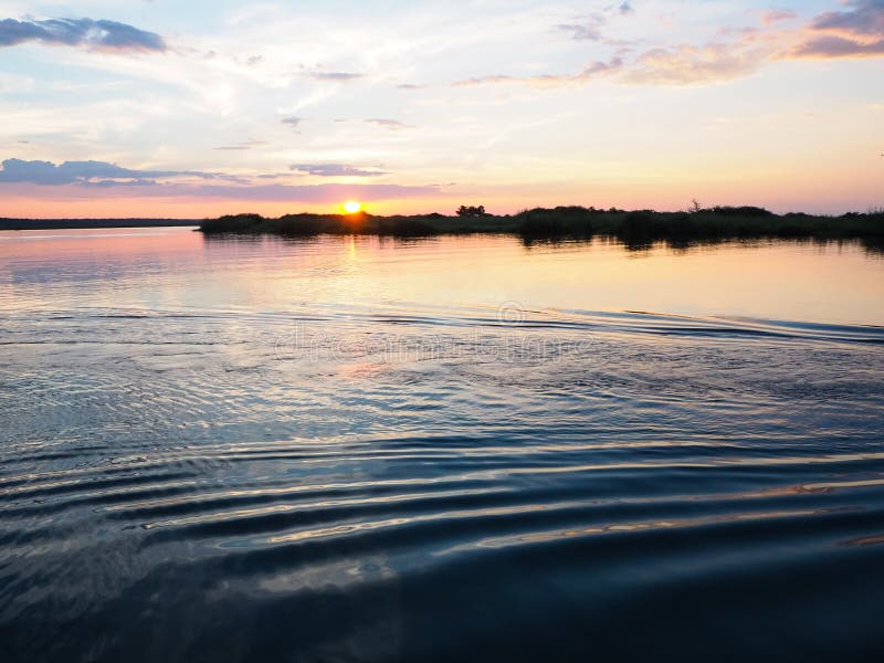 Sunset scenic view at the river bank with water ripple and sweet color sky. Sunset scenic view at the river bank with water ripple and sweet color sky