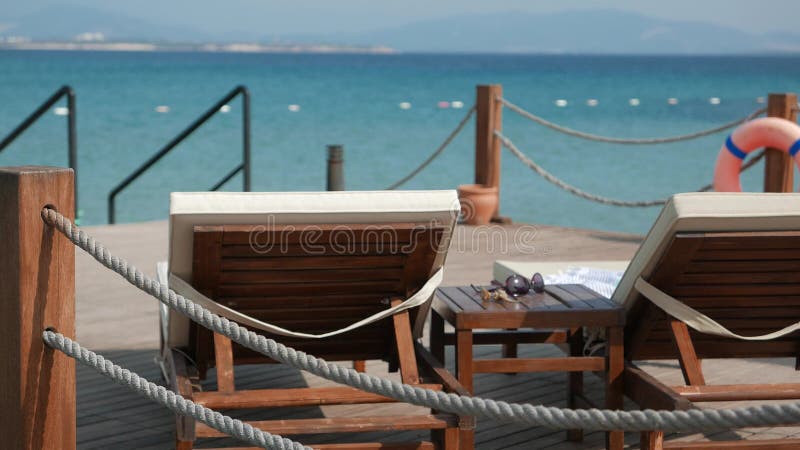 Σκηνή μιας ηλιόλουστης ημέρας με τις κενές ξύλινες καρέκλες γεφυρών απόθεμα βίντεο