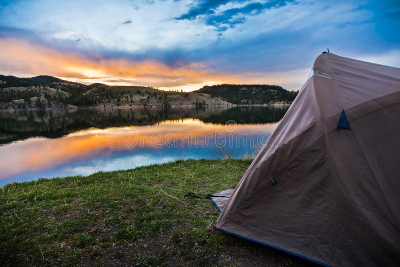 Tent camping set up by the lakeshore of a mountain lake. Tent camping set up by the lakeshore of a mountain lake.