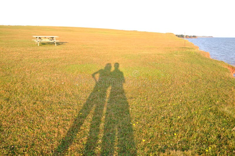 A nice couple shadow in Argyle Shore Provincial Park, Prince Edward Island, Canada, with golden color grass near the ocean. A nice couple shadow in Argyle Shore Provincial Park, Prince Edward Island, Canada, with golden color grass near the ocean.