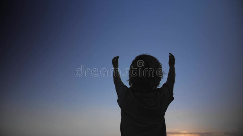 Σκιαγραφία παιδιών που αυξάνει τα χέρια επάνω στον αέρα στο υπόβαθρο μπλε ουρανού