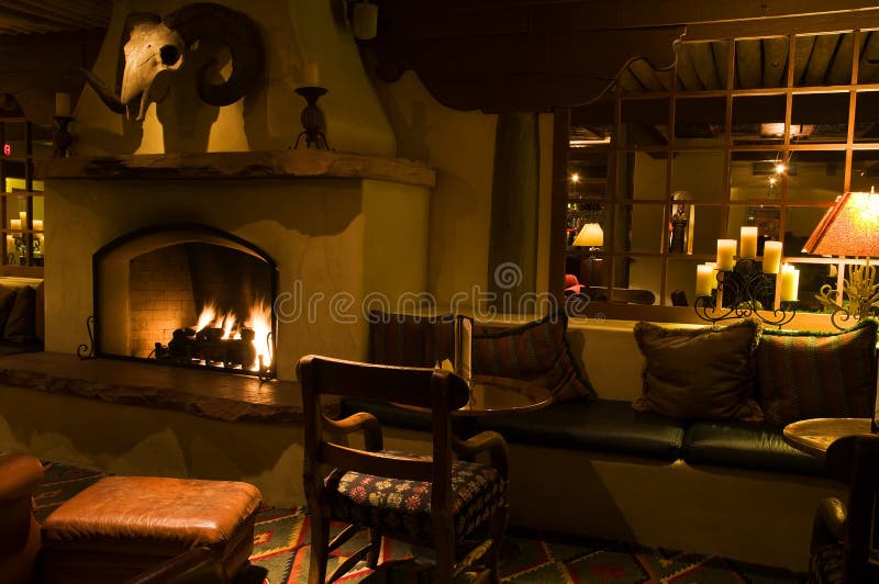 A view of a comfortable, dark hotel lounge with a fireplace. A view of a comfortable, dark hotel lounge with a fireplace.