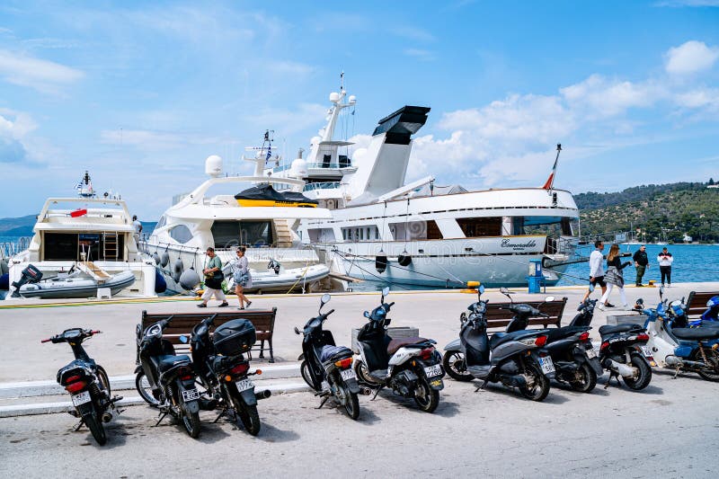 Σκούτερ παρκαρισμένοι κατά μήκος της παραθαλάσσιας οδού στο νησί Πόρο Ελλάδα στοκ εικόνες