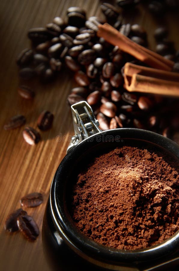 Coffee powder with coffee bean and cinnamon stick in background. Coffee powder with coffee bean and cinnamon stick in background