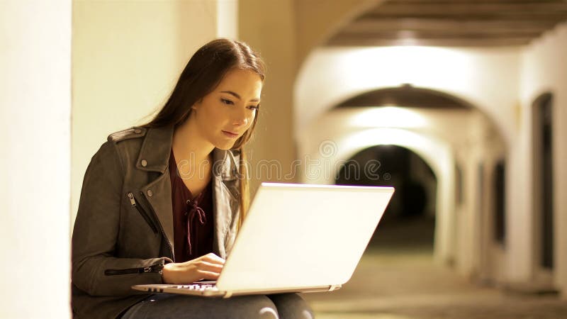 Σοβαρή δακτυλογράφηση γυναικών σε ένα lap-top στη νύχτα φιλμ μικρού μήκους