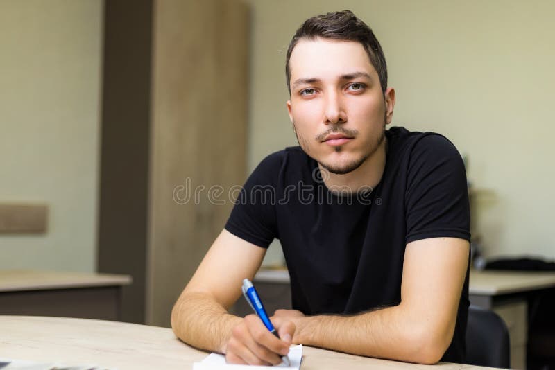 σοβαρός άνδρας ή ενήλικας στην εργασία εξετάζει άμεσα το θαμπό υπόβαθρο του γραφείου στοκ εικόνες