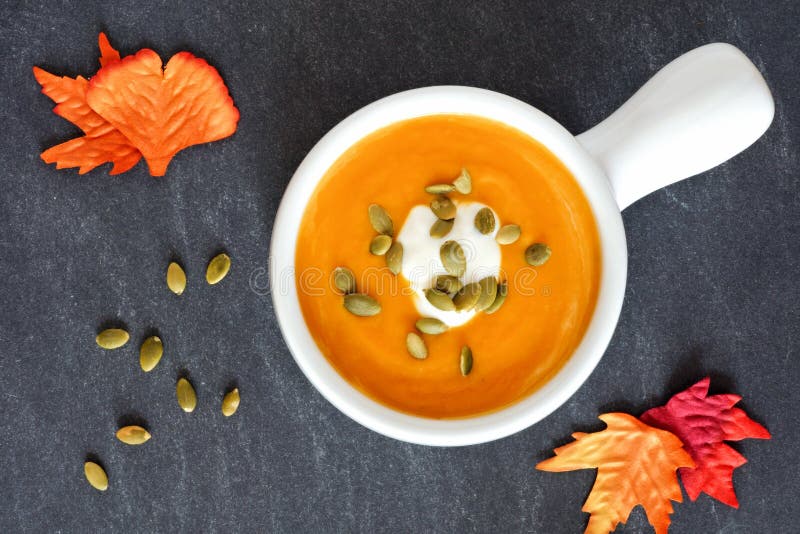 Σούπα κολοκύνθης φθινοπώρου butternut στο υπόβαθρο πλακών στοκ φωτογραφία