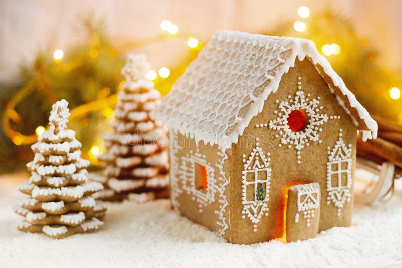 Σπίτι μελοψωμάτων και χριστουγεννιάτικα δέντρα σε ένα φωτεινό υπόβαθρο Επίδραση Bokeh