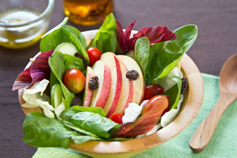 Apple,raisin and spinach salad in a bowl. Apple,raisin and spinach salad in a bowl