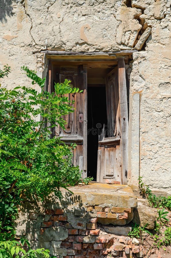 σπασμένη ξύλινη πόρτα ενός παλιού κατεστραμμένου κτιρίου. παλιό κατεστραμμένο κτίριο και καφέ αντίκα ξύλινη πόρτα στοκ εικόνες