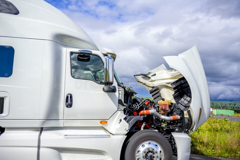 Broken Big rig industrial professional white semi truck with open hood and long haul semi trailer standing on the road shoulder trying to fix breakdown in place and waiting for road repair assistant. Broken Big rig industrial professional white semi truck with open hood and long haul semi trailer standing on the road shoulder trying to fix breakdown in place and waiting for road repair assistant.