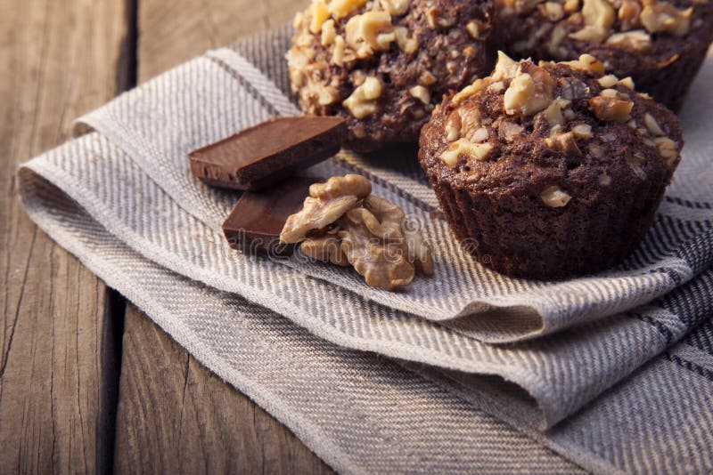 Σπιτικά εύγευστα Muffins σοκολάτας με το ξύλο καρυδιάς στο ξύλινο backrou στοκ εικόνες με δικαίωμα ελεύθερης χρήσης