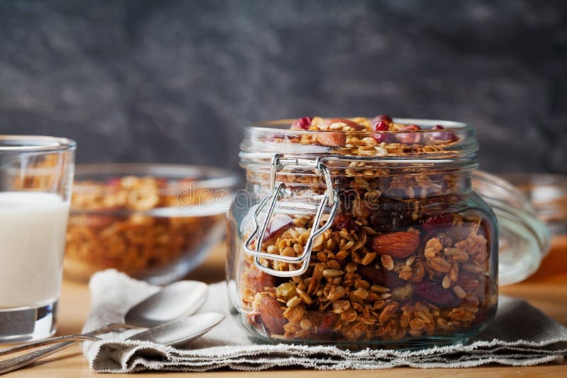 Σπιτικό granola στο βάζο στον αγροτικό πίνακα, υγιές πρόγευμα oatmeal του muesli, καρύδια, σπόροι και ξηρός - φρούτα στοκ εικόνα με δικαίωμα ελεύθερης χρήσης