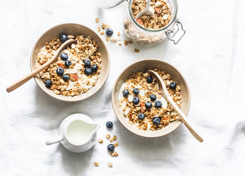 Σπιτικό granola φυστικοβουτύρου με το ελληνικό γιαούρτι και βακκίνια σε ένα ελαφρύ υπόβαθρο, τοπ άποψη Υγιές ενεργειακό πρόγευμα στοκ εικόνες με δικαίωμα ελεύθερης χρήσης