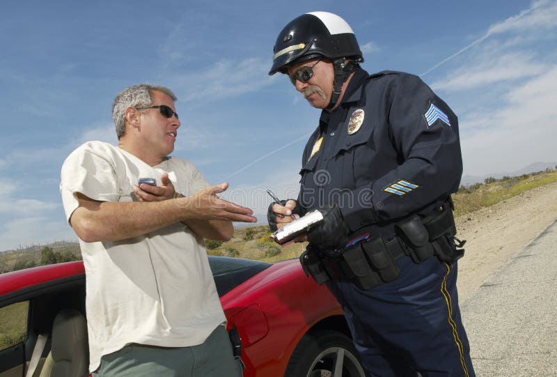 Traffic cop writing a ticket for driver of sports car. Traffic cop writing a ticket for driver of sports car