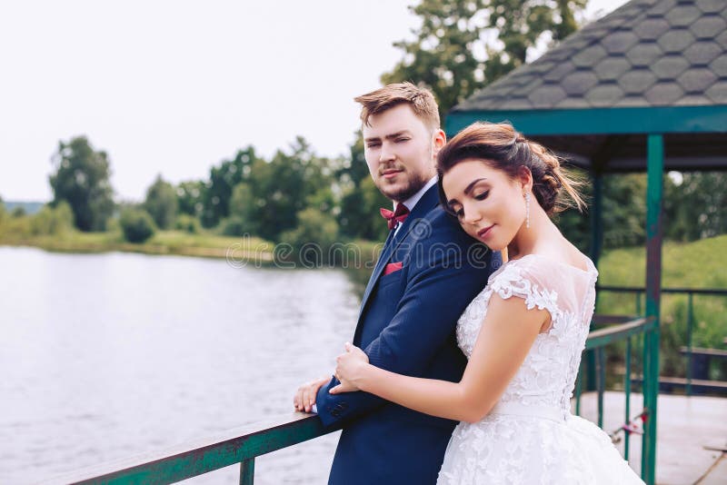 Στάση Newlyweds στην αποβάθρα σε έναν εναγκαλισμό στοκ εικόνα