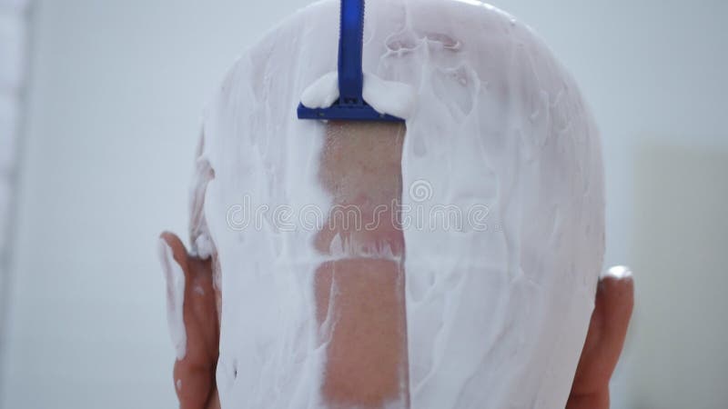 Στενή εικόνα με το άτομο που ξυρίζει το κεφάλι του στο λουτρό στοκ φωτογραφία με δικαίωμα ελεύθερης χρήσης