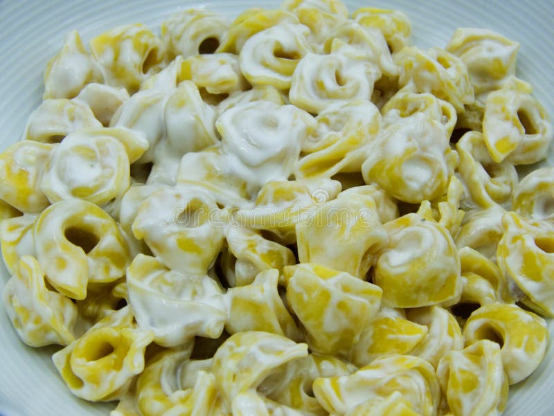 Στενός επάνω panna alla Tortellini σε ένα άσπρο πιάτο, ιταλικά ζυμαρικά στοκ εικόνα