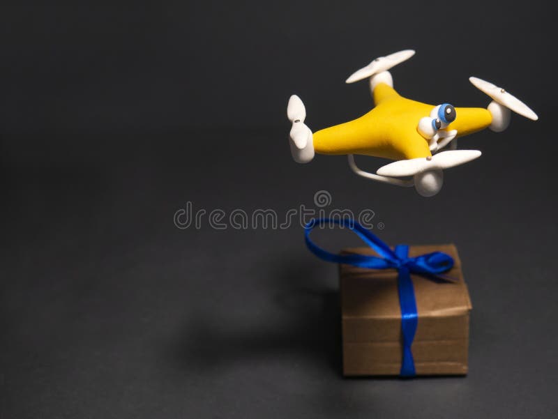 Στενός ο επάνω κηφήνων του quadrocopter με το δέμα κουρασμένος στοκ φωτογραφίες με δικαίωμα ελεύθερης χρήσης Στενός ο επάνω κηφήνων του quadrocopter με το δέμα κουρασμένος στοκ φωτογραφίες με δικαίωμα ελεύθερης χρήσης