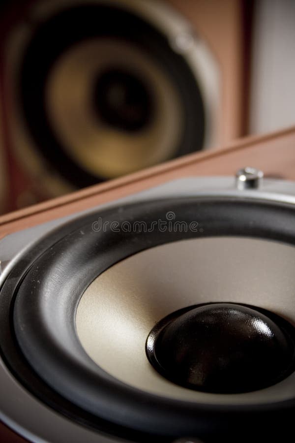 Closeup of a stereo speaker, with another speaker standing in the background. Closeup of a stereo speaker, with another speaker standing in the background.
