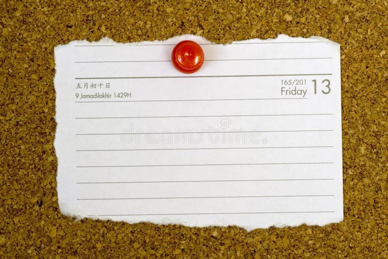 Piece of paper showing the date Friday 13 pegged to a cork board. Piece of paper showing the date Friday 13 pegged to a cork board