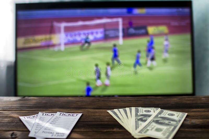 Στη TV είναι ποδόσφαιρο στον πίνακα στοιχηματίζει τα εισιτήρια και τα δολάρια χρημάτων, αθλητικά στοιχήματα στοκ εικόνες με δικαίωμα ελεύθερης χρήσης Στη TV είναι ποδόσφαιρο στον πίνακα στοιχηματίζει τα εισιτήρια και τα δολάρια χρημάτων, αθλητικά στοιχήματα στοκ εικόνες με δικαίωμα ελεύθερης χρήσης