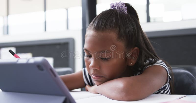 στην σχολική τάξη μια νεαρή αφρικανή κοπέλα επικεντρώνεται στο tablet της