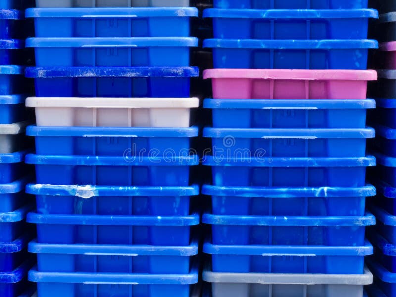 Background texture pattern of stacks of empty colorful plastic containers as used in fishery, wholesale, storage of fresh produce, cargo and retail transportation. Background texture pattern of stacks of empty colorful plastic containers as used in fishery, wholesale, storage of fresh produce, cargo and retail transportation