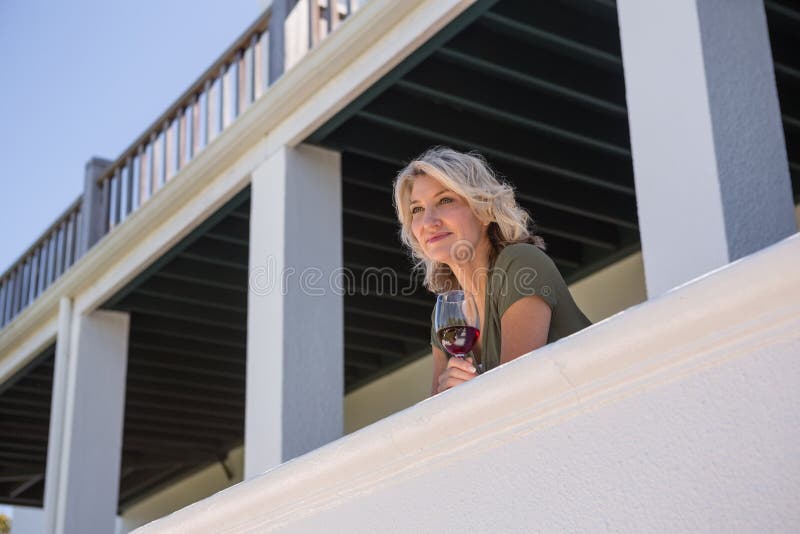 Στοχαστική γυναίκα που κρατά το άσπρο γυαλί κρασιού στο μπαλκόνι στο εστιατόριο στοκ φωτογραφία με δικαίωμα ελεύθερης χρήσης Στοχαστική γυναίκα που κρατά το άσπρο γυαλί κρασιού στο μπαλκόνι στο εστιατόριο στοκ φωτογραφία με δικαίωμα ελεύθερης χρήσης