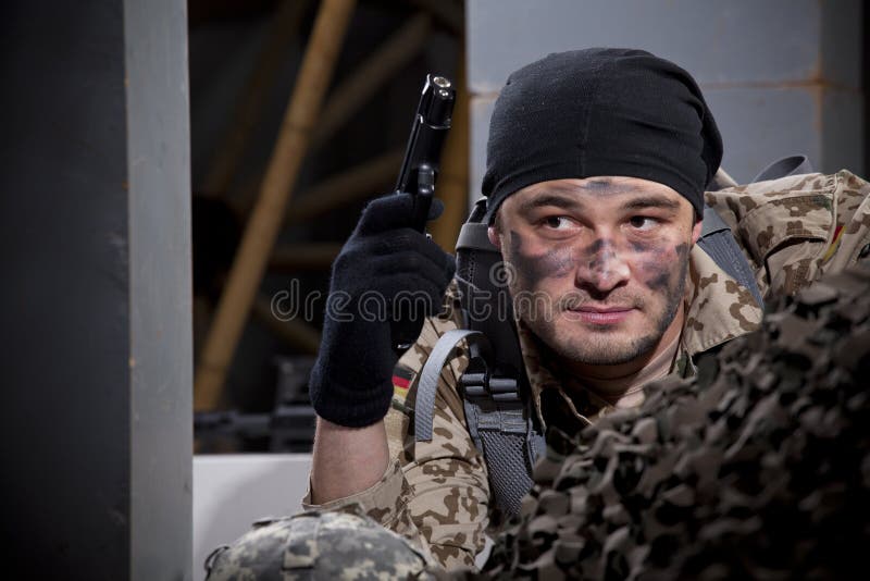 Soldier in camouflage hiding in ruins holding a gun. Soldier in camouflage hiding in ruins holding a gun