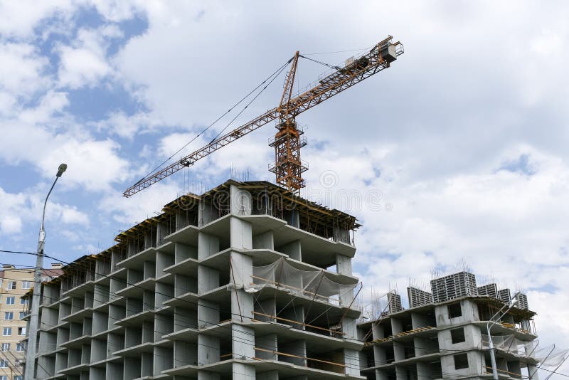 Συγκεκριμένα πλαίσια των κτηρίων και ένας γερανός οικοδόμησης επάνω από τους στοκ εικόνες Συγκεκριμένα πλαίσια των κτηρίων και ένας γερανός οικοδόμησης επάνω από τους στοκ εικόνες