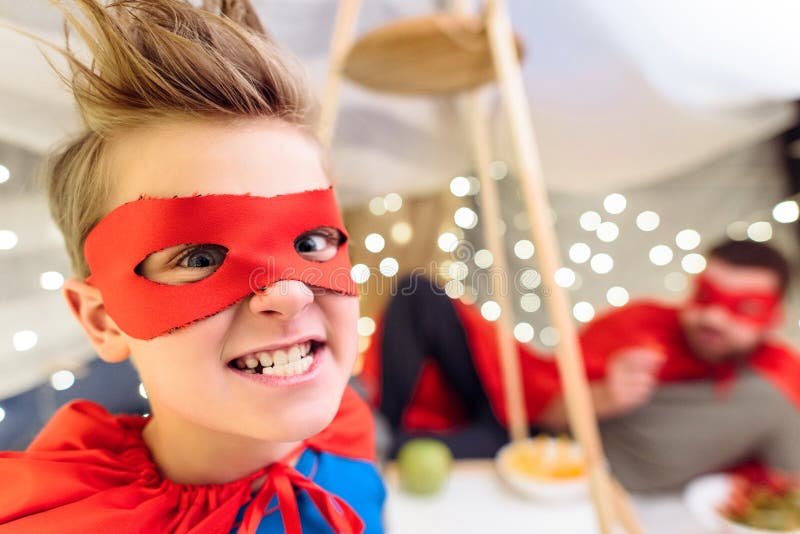 Συγκινημένο μικρό παιδί στο κοστούμι superhero που εξετάζει τη κάμερα στοκ φωτογραφία Συγκινημένο μικρό παιδί στο κοστούμι superhero που εξετάζει τη κάμερα στοκ φωτογραφία