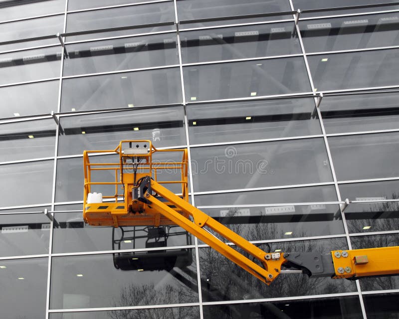 Cerry picker in front of a modern building. Cerry picker in front of a modern building