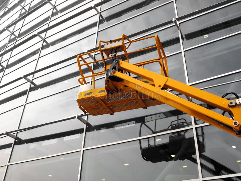 Cherry picker in front of a modern building. Cherry picker in front of a modern building